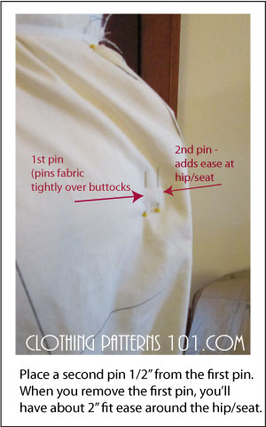 pinning the pant close to the body form, and a second pin to add ease at the hip.